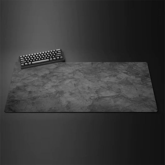 Gray cloth desk mat with stitched edges under a keyboard and mouse