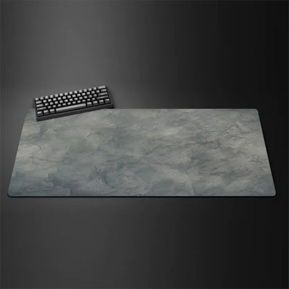 Gray cloth desk mat with stitched edges under a keyboard and mouse