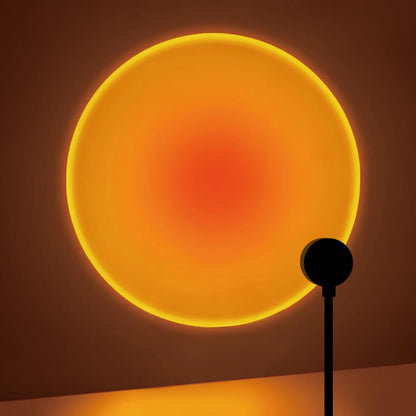 USB sunset projection lamp casting a warm round glow on a wall behind a desk