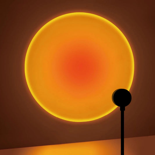 USB sunset projection lamp casting a warm round glow on a wall behind a desk