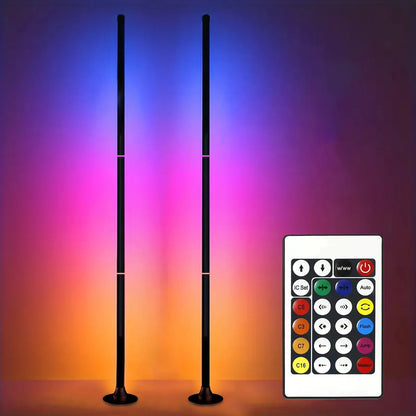 Slim RGB corner floor lamp lighting a wall in color behind a gaming desk
