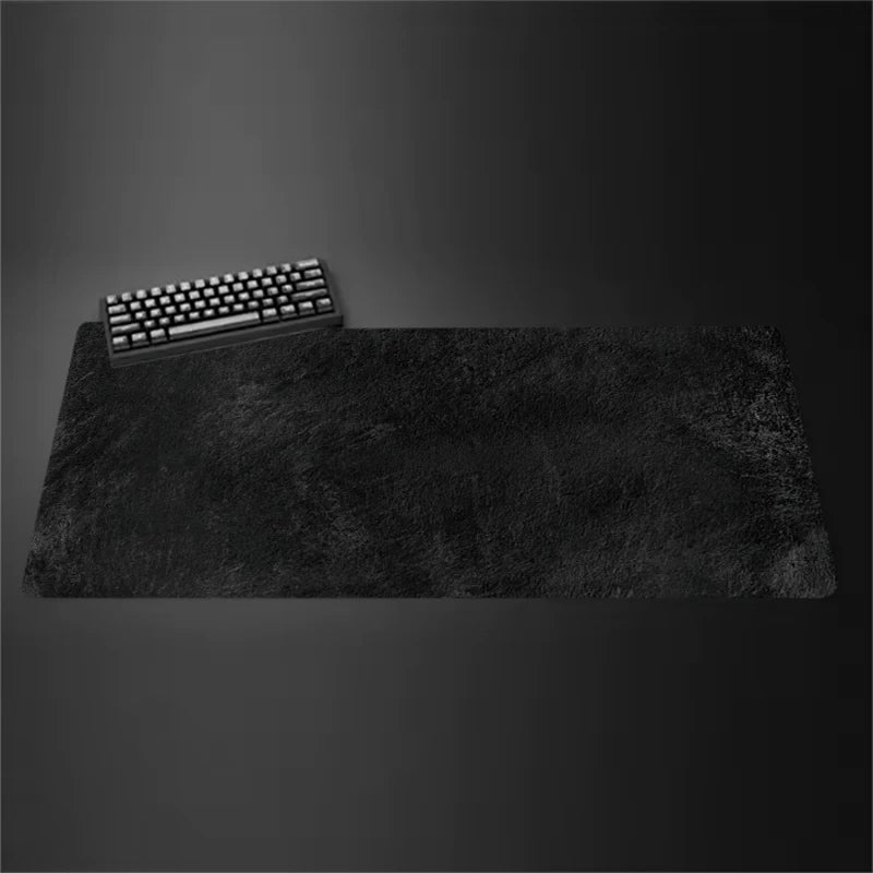 Gray cloth desk mat with stitched edges under a keyboard and mouse