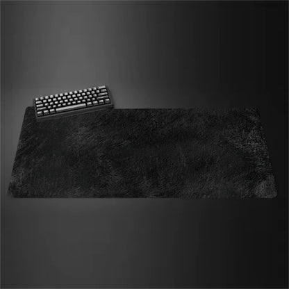 Gray cloth desk mat with stitched edges under a keyboard and mouse
