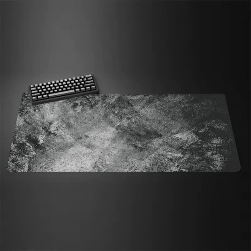 Gray cloth desk mat with stitched edges under a keyboard and mouse