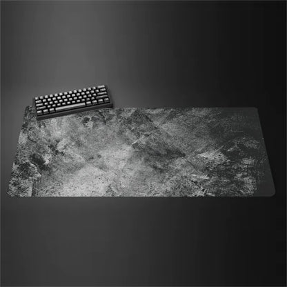Gray cloth desk mat with stitched edges under a keyboard and mouse