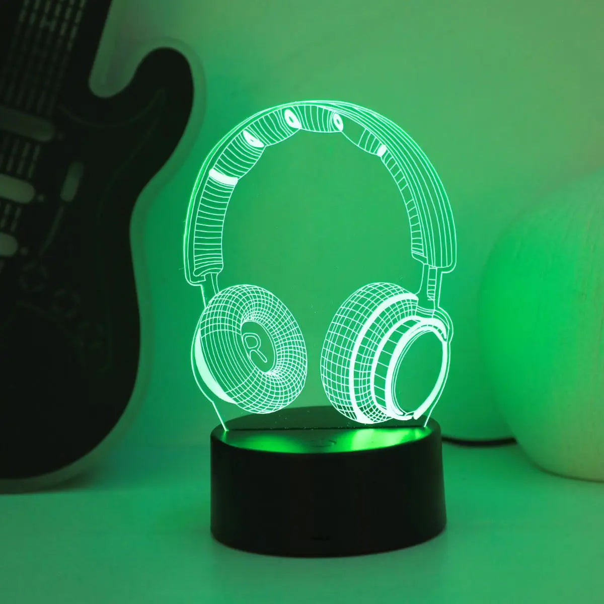 Headphones night light glowing green on a lit base