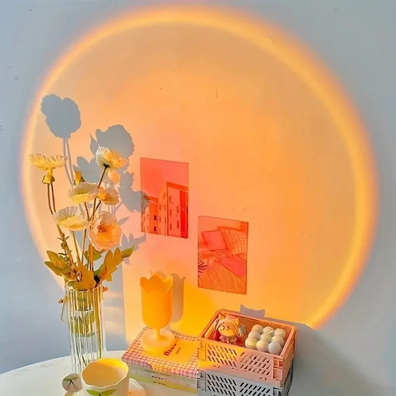 USB sunset projection lamp casting a warm round glow on a wall behind a desk