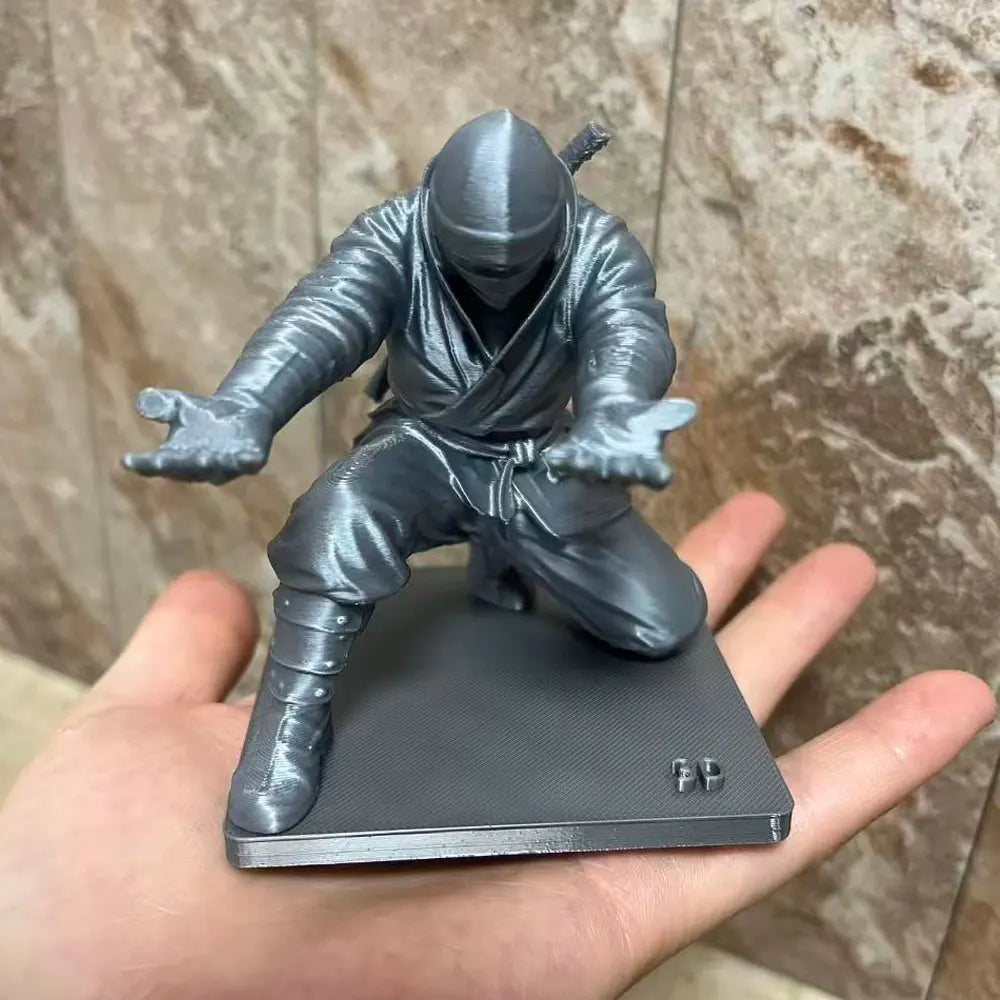 3D printed ninja figure pen holder holding pens on a desk