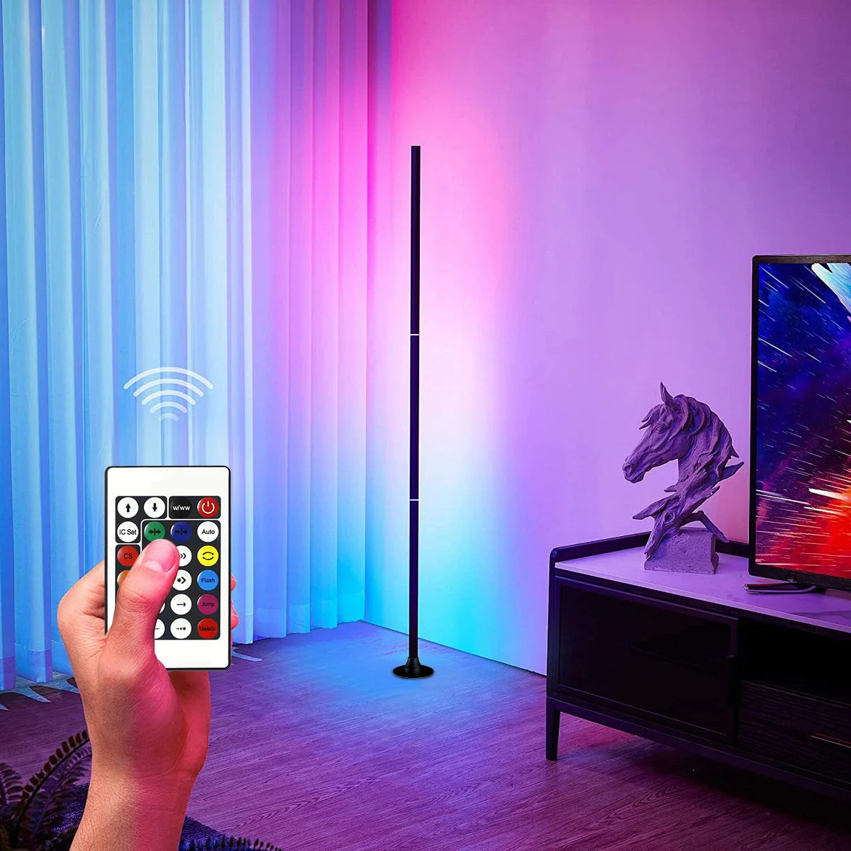 Slim RGB corner floor lamp lighting a wall in color behind a gaming desk